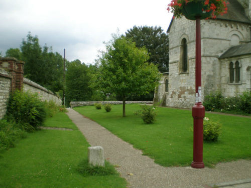 Les abords de l'église Saint-Ouen de Léry : allée, pelouse et mur de pierre