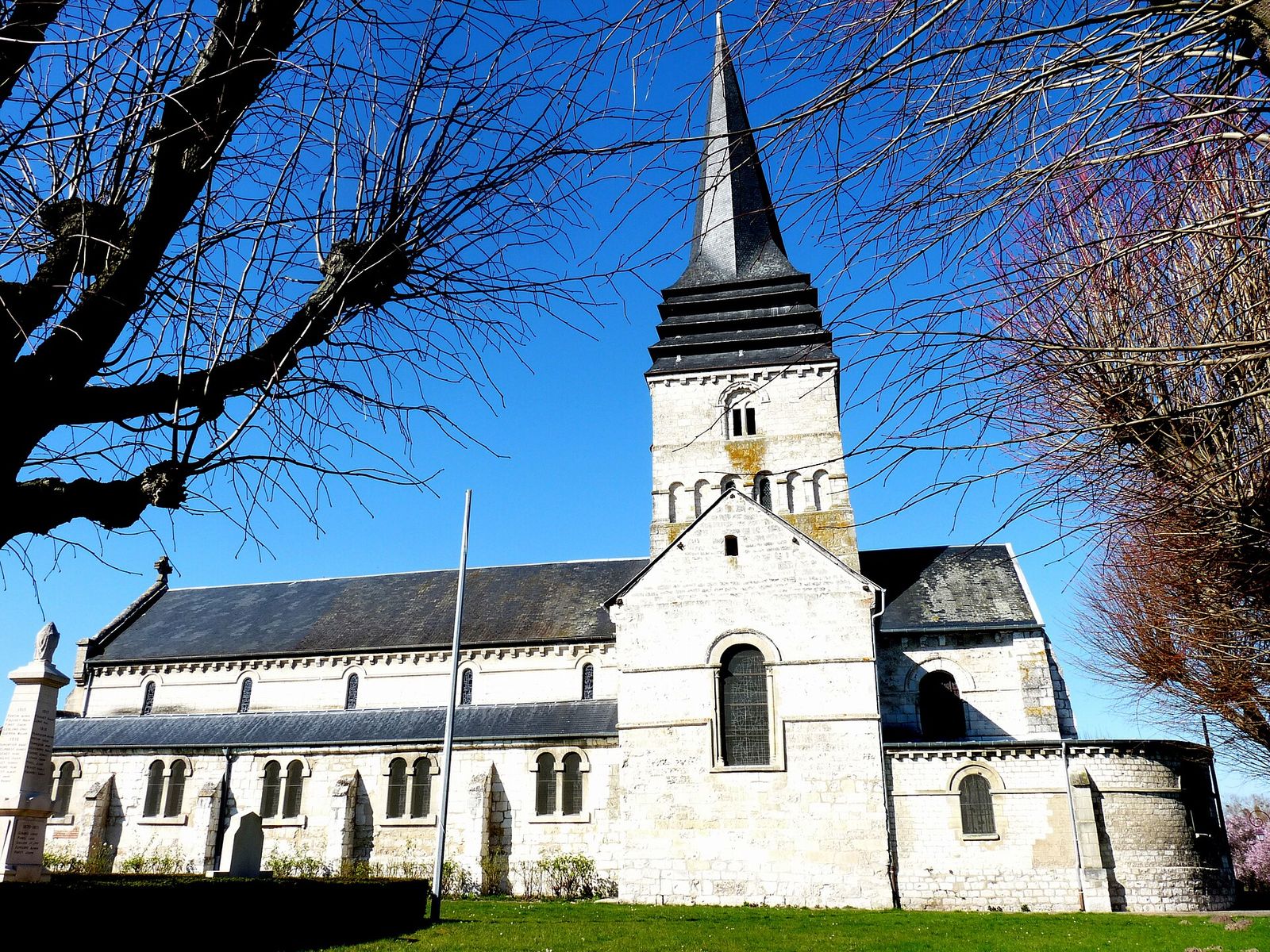 L'église Saint-Ouen de Léry, en pierre blanche sous un ciel bleu